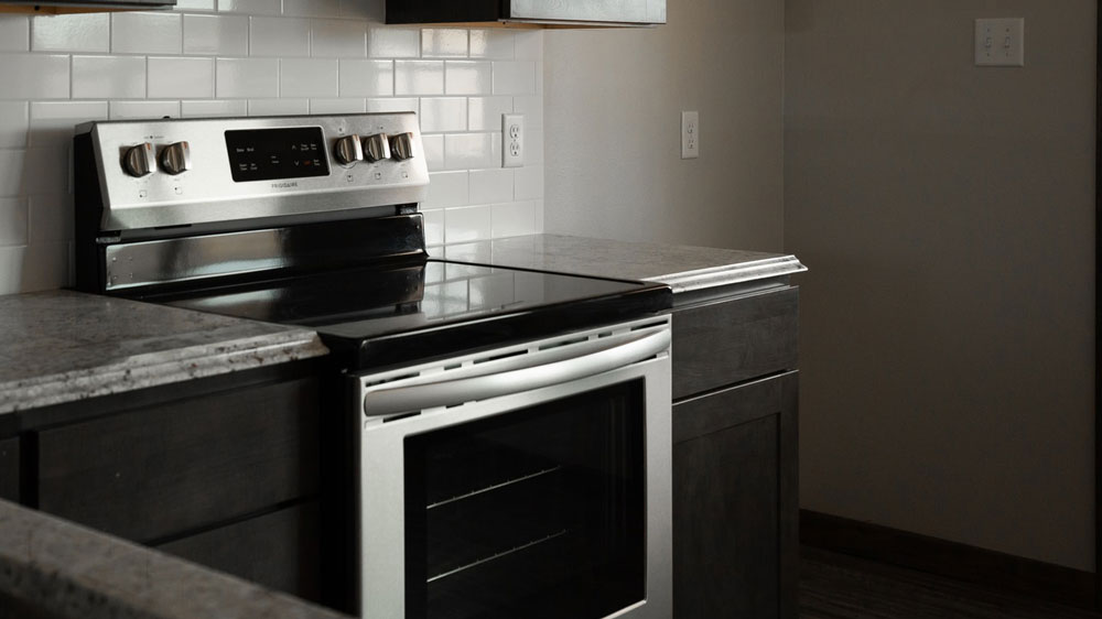 A stainless steel stove with a flat cooktop